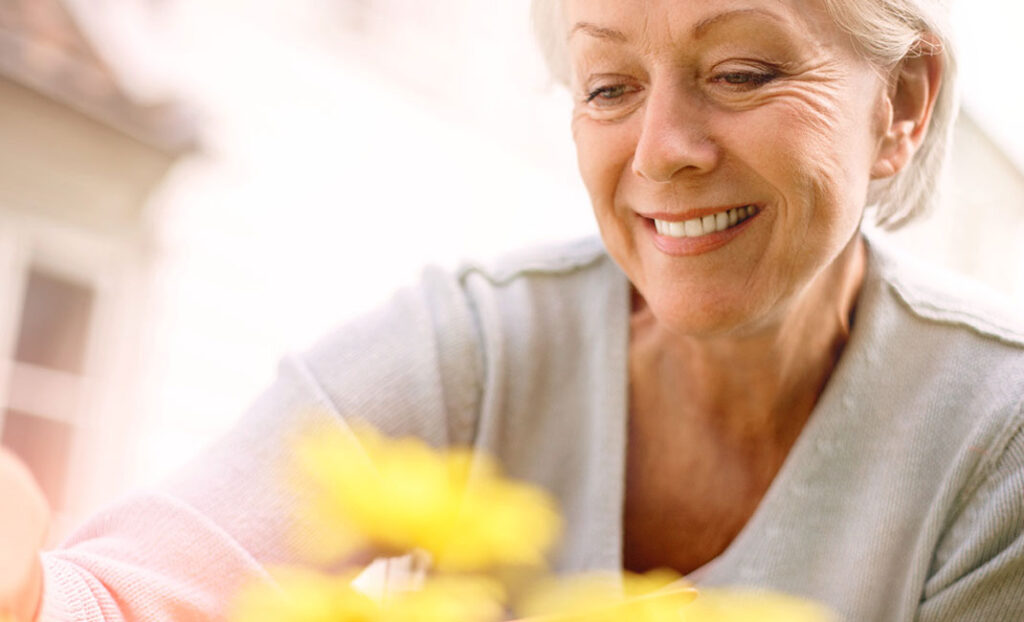 Eine Frau bei Sonnenschein am Blumen pflanzen