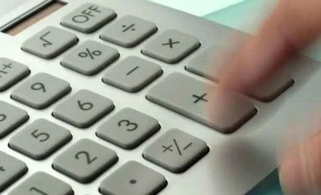 Ein verschwommener Finger bedient einen Taschenrechner